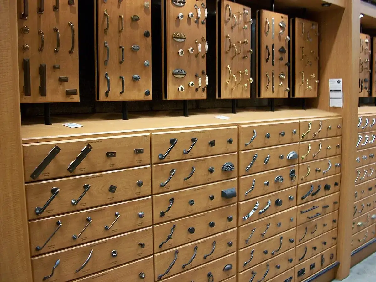 Showroom wall display of cabinet pulls, knobs and handles mounted on wood sample panels