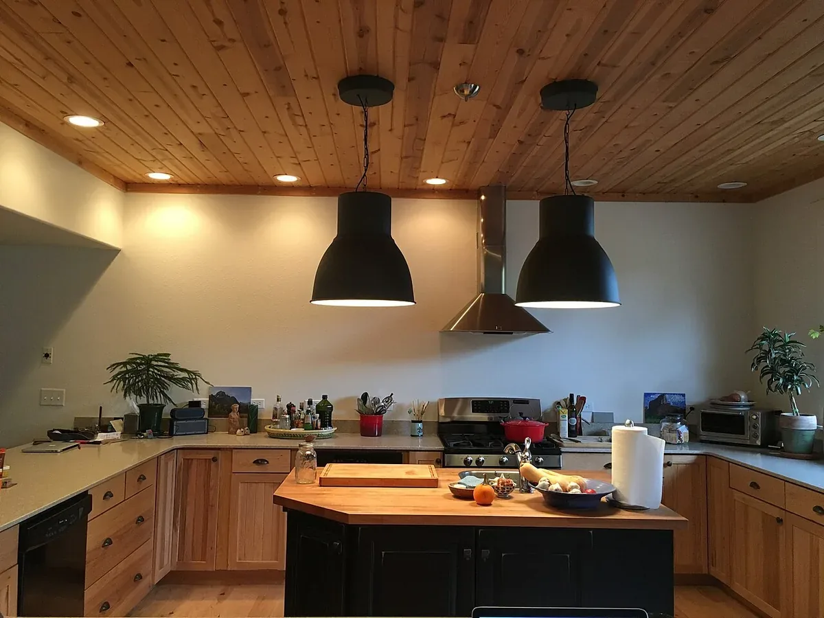 Lived in kitchen with light hickory shaker cabinets and a black painted island with a butcher block top, the style of custom cabinetry built for Santa Maria CA homes
